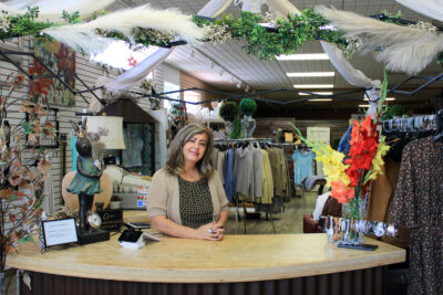 employer and owner of crabbapples, a mens clothing store in wainwright alberta, standing at a counter with merchandise in the background