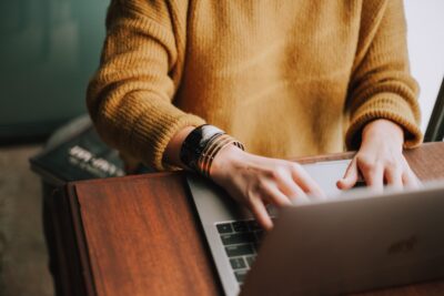 a worker at a desk typing on a laptop highlighting BRAED online and employment training services