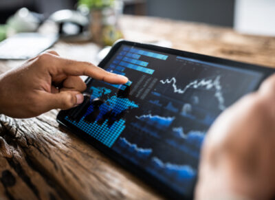 a tablet screen closeup with financial graphs in blue against a black background, highlighting economic investment into the battle river region